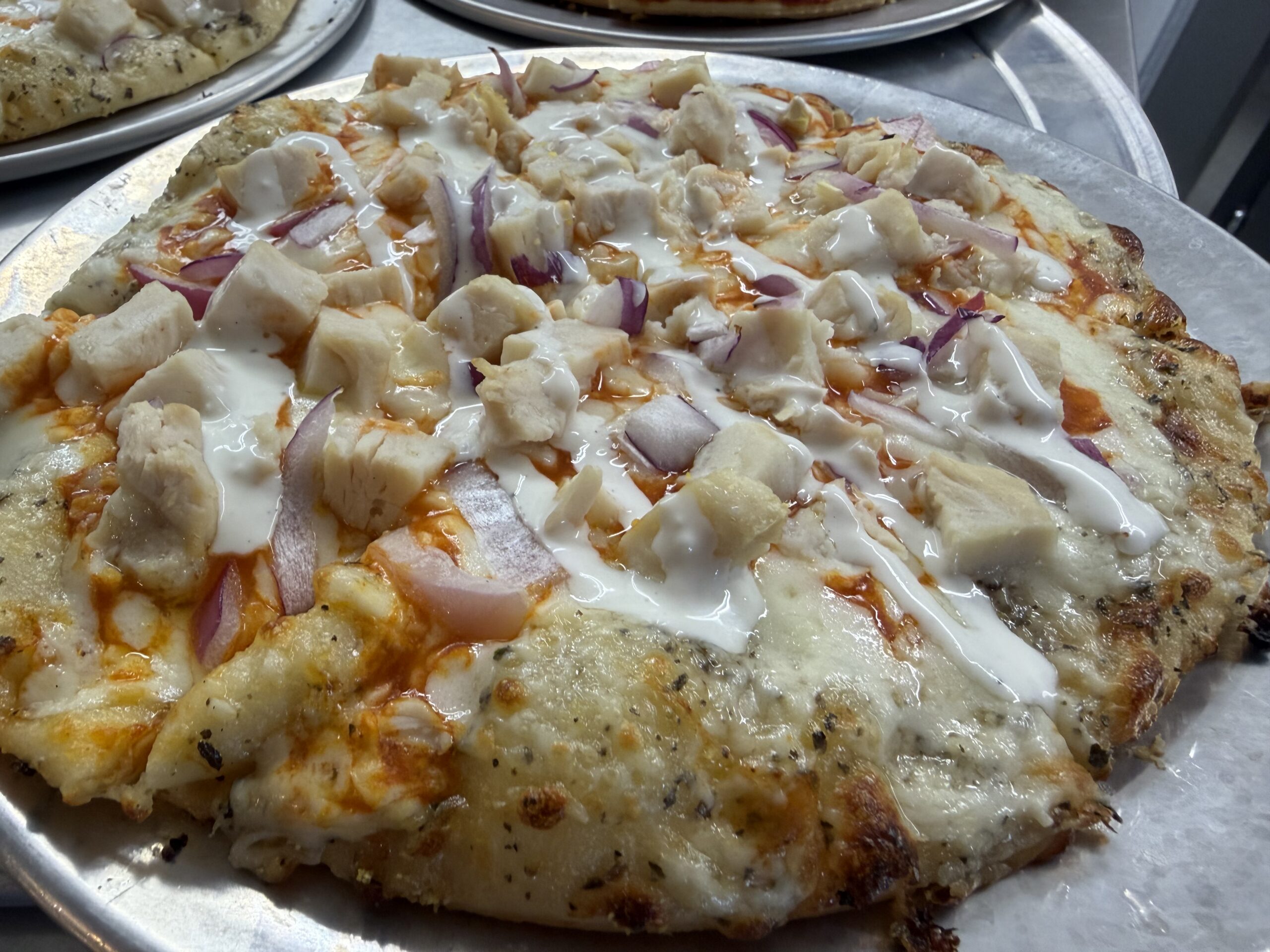Buffalo chicken pizza with red onion and cilantro