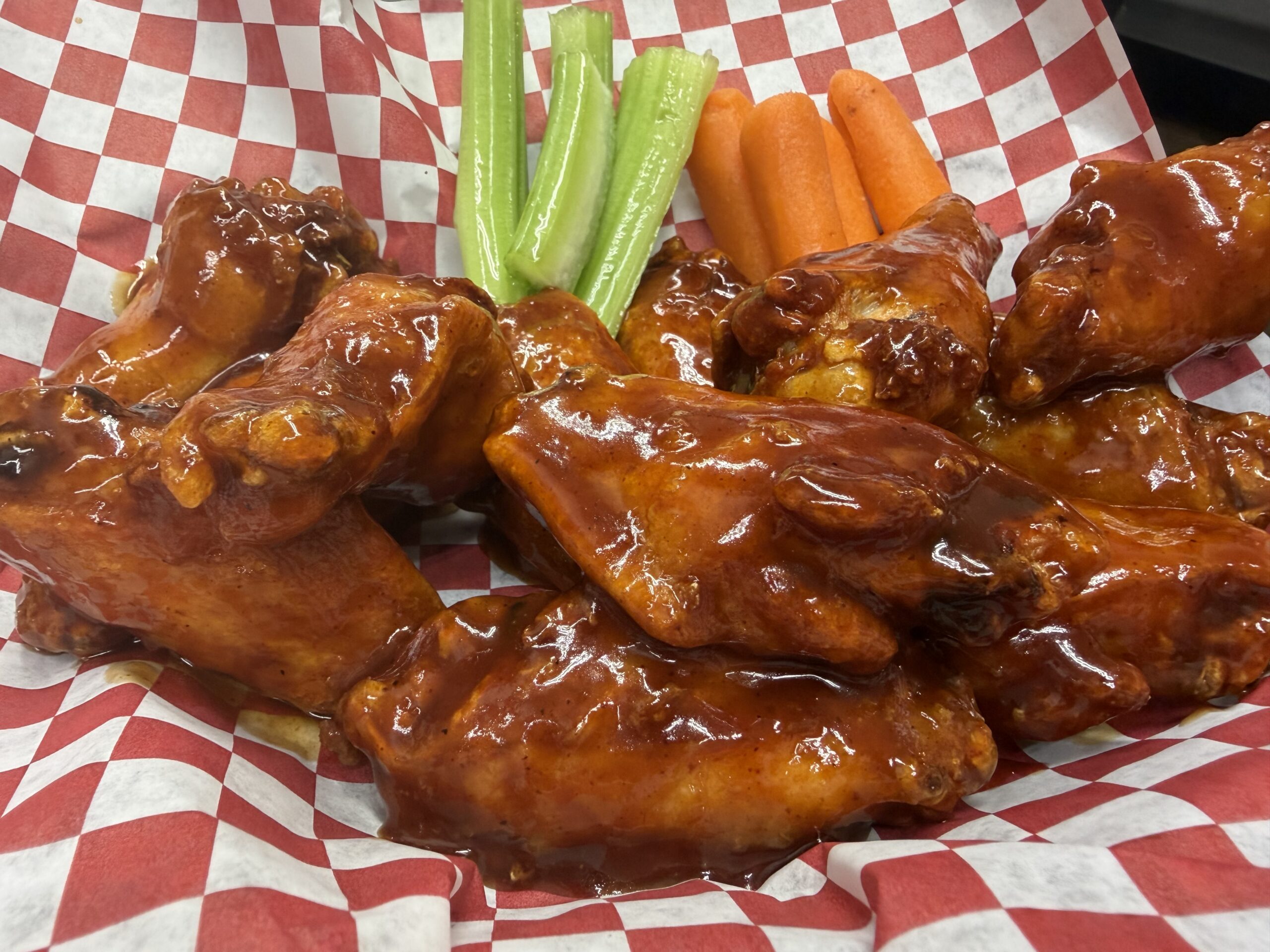Sauced chicken wings with carrots and celery